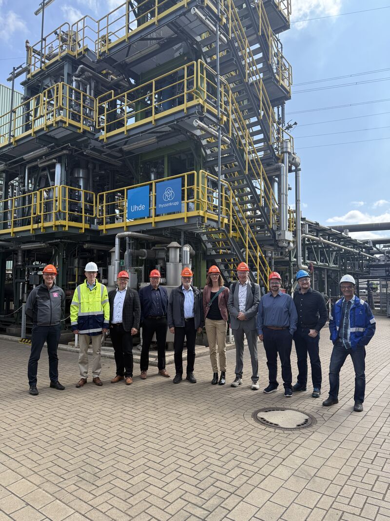 Gruppenfoto der Gäste von HydrOB, evo und Fraunhofer UMSICHT mit Schutzhelmen vor der Versuchsanlage