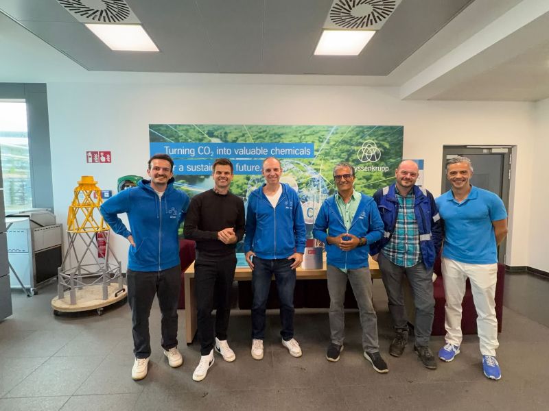 Gruppenfoto der Gäste aus Ostwestfalen vor der Wand „Turning CO₂ into valuable chemicals“