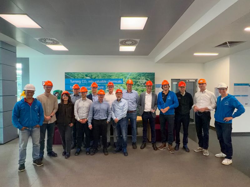 Gruppenfoto der Gäste von Uhde High Pressure Technologies mit Schutzhelmen im Empfangsbereich